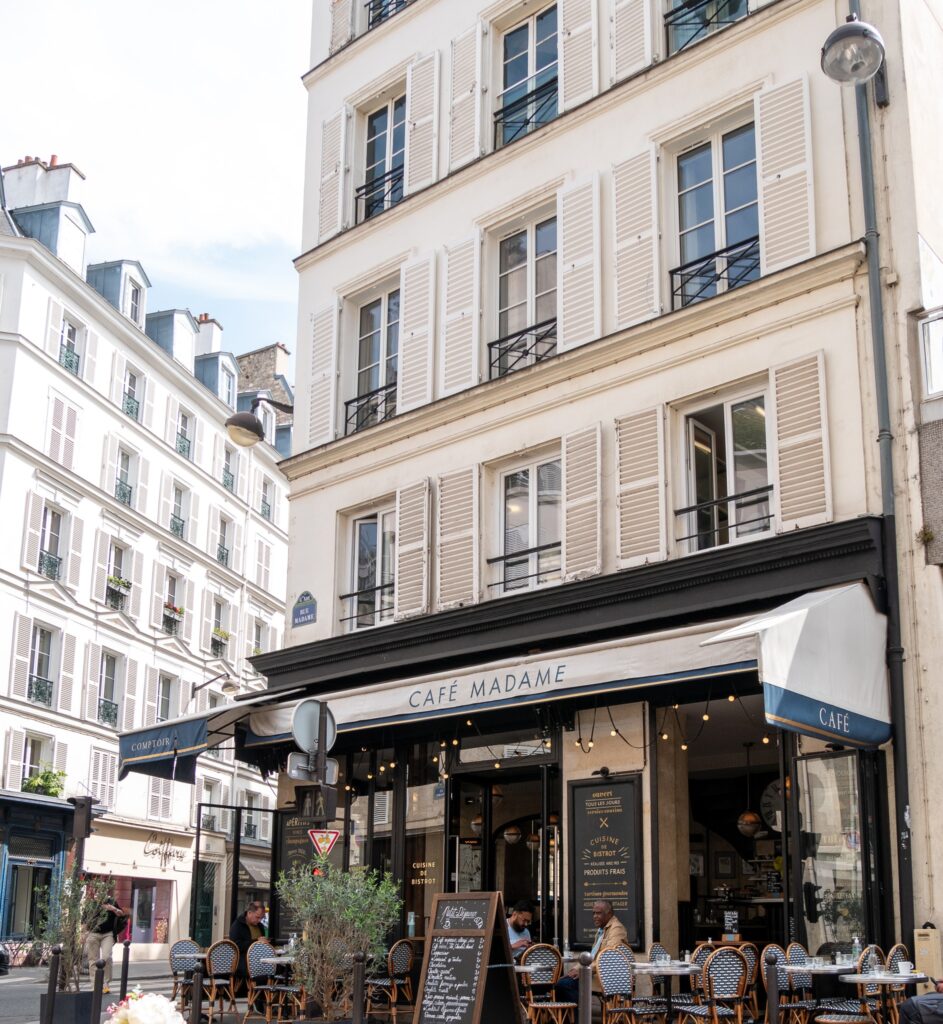 Exterior of Café Madame with Parisian outdoor seating. Parisian cafés
