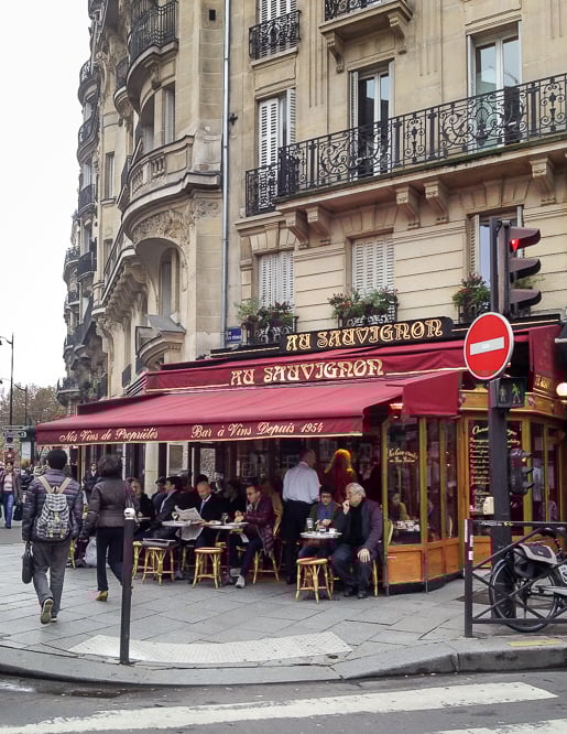 The vibrant red awning of Le Sauvignon café in Paris. Parisian cafés