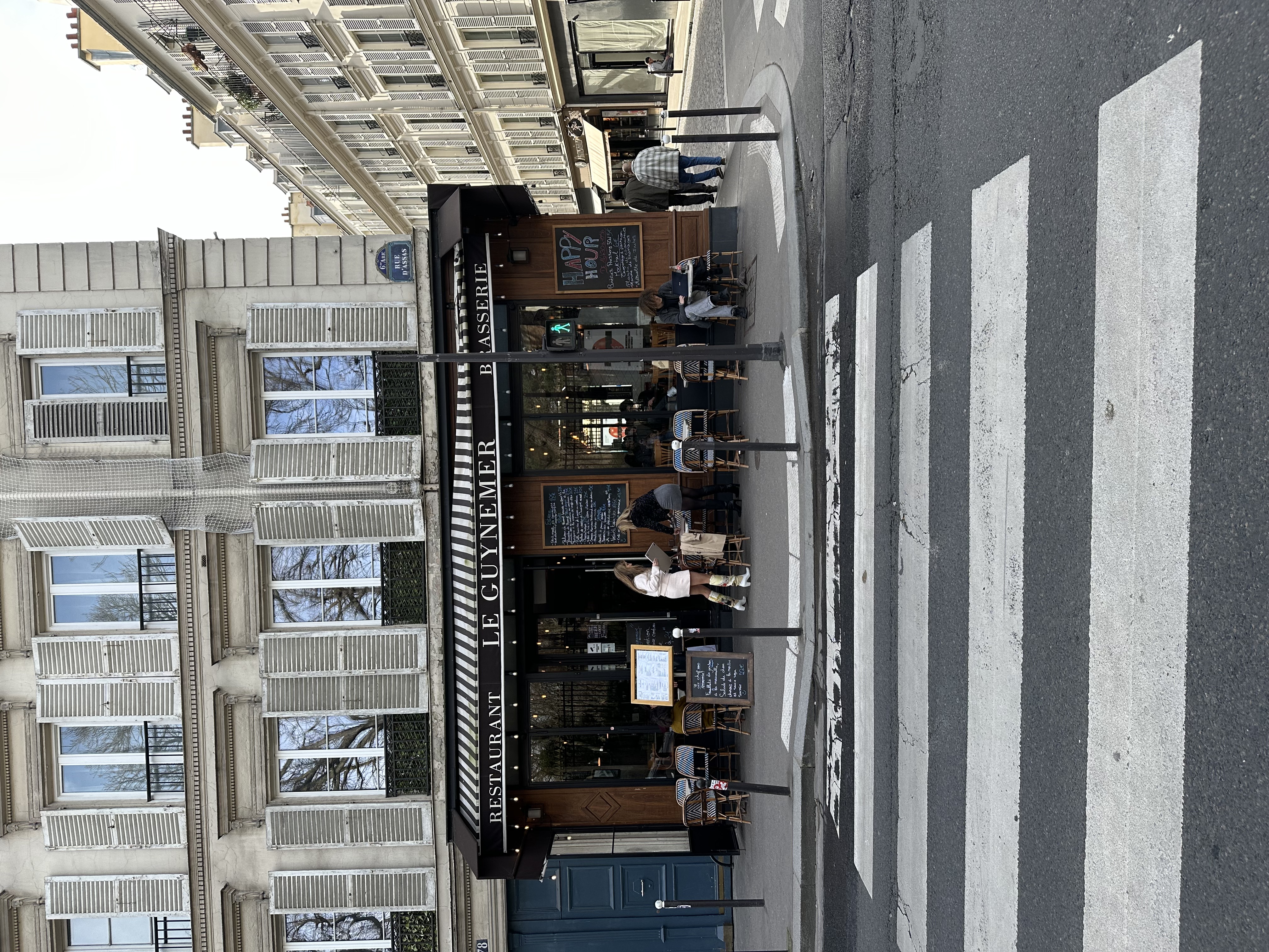 Street view of Le Guynemer café with outdoor tables. Parisian cafés