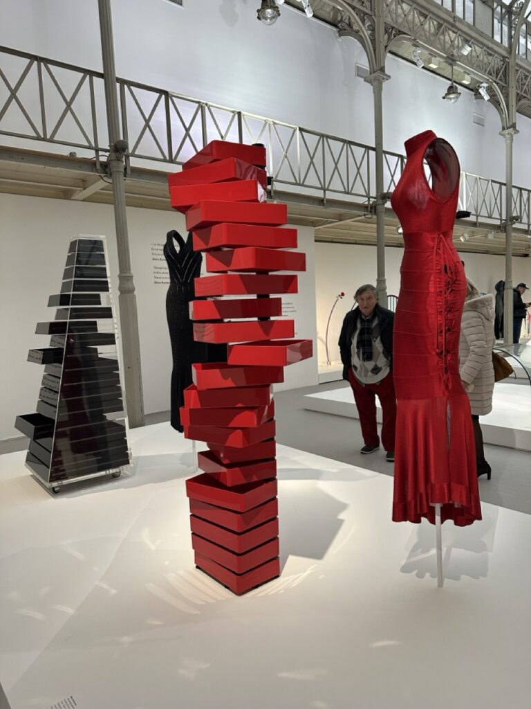 Red stacked box sculpture and a red Alaïa gown at the Alaïa/Kuramata exhibit.