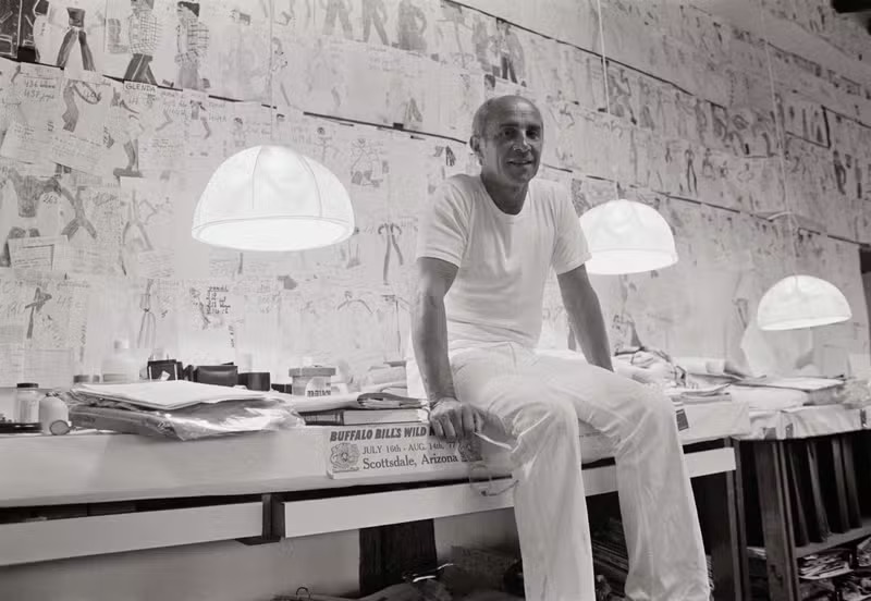 André Courrèges in his design studio, surrounded by sketches that define his revolutionary fashion vision.