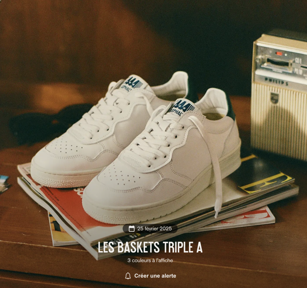 A pair of white Asphalte Triple A sneakers resting on vintage magazines, representing a high-quality and customizable French sneaker brand.