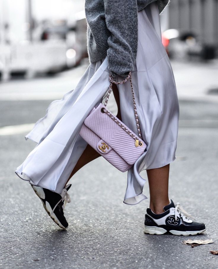 Chanel sneakers paired with a flowing skirt and a pastel Chanel handbag, showcasing luxury French sneaker brands.
