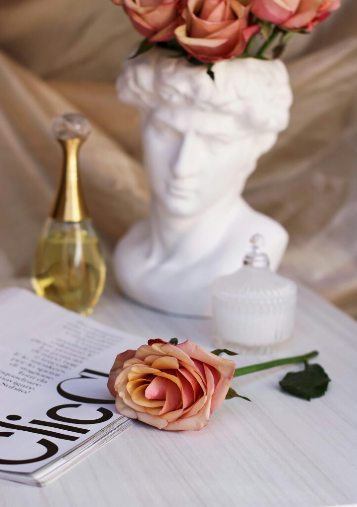 A Dior, French perfume brand, bottle displayed with a classical sculpture and flowers.