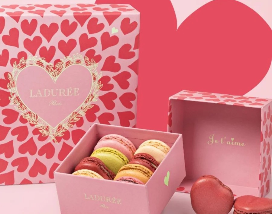 Pink Ladurée Valentine's Day macaron box with hearts and colorful macarons inside.
