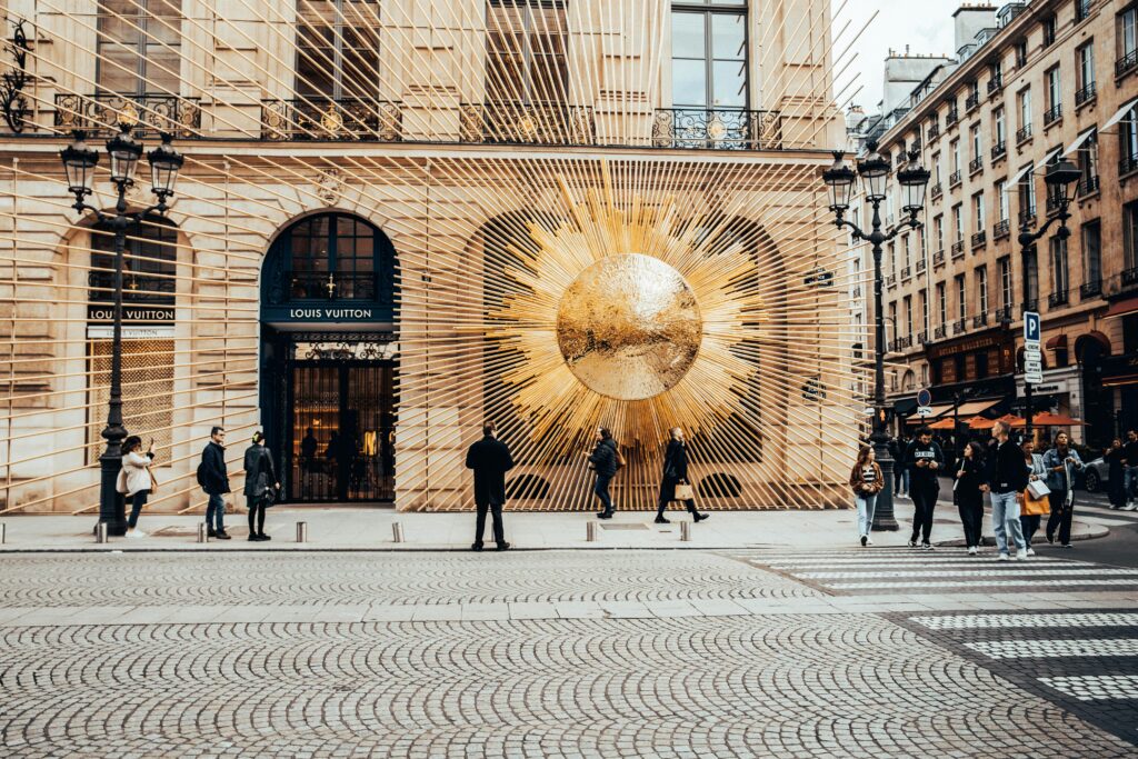 The exterior of the Louis Vuitton boutique at Place Vendôme in Paris, featuring a striking golden sunburst display. What to buy in Paris.