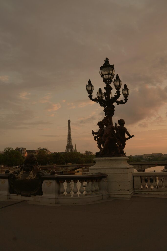 The ornate lampposts of Pont Alexandre III in Paris with the Eiffel Tower in the background.