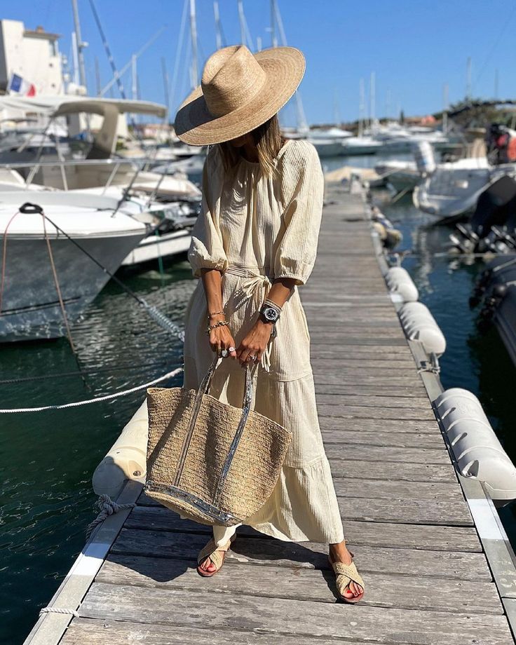Woman carrying a Vanessa Bruno raffia tote with casual summer attire.
