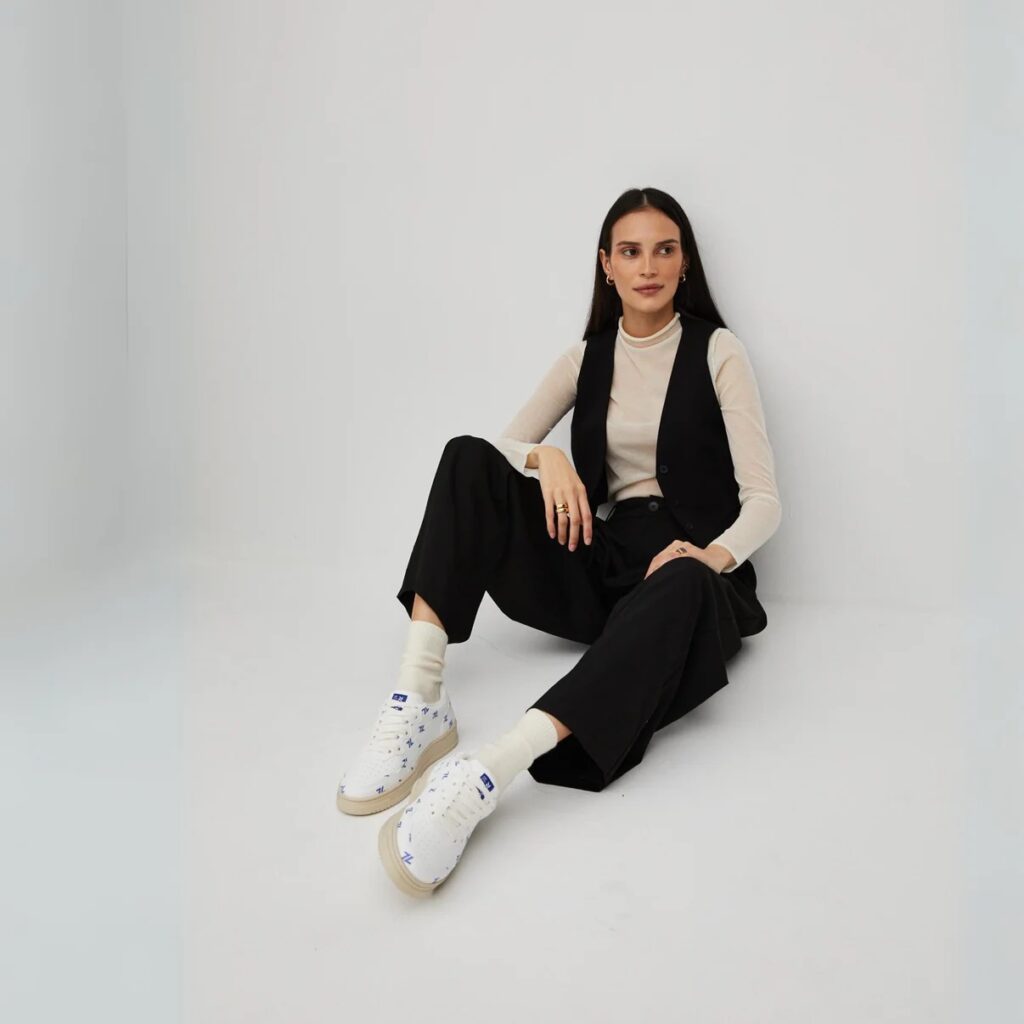 A woman wearing Zèta sneakers, an innovative sustainable pick from French sneaker brands, paired with a sleek black outfit.