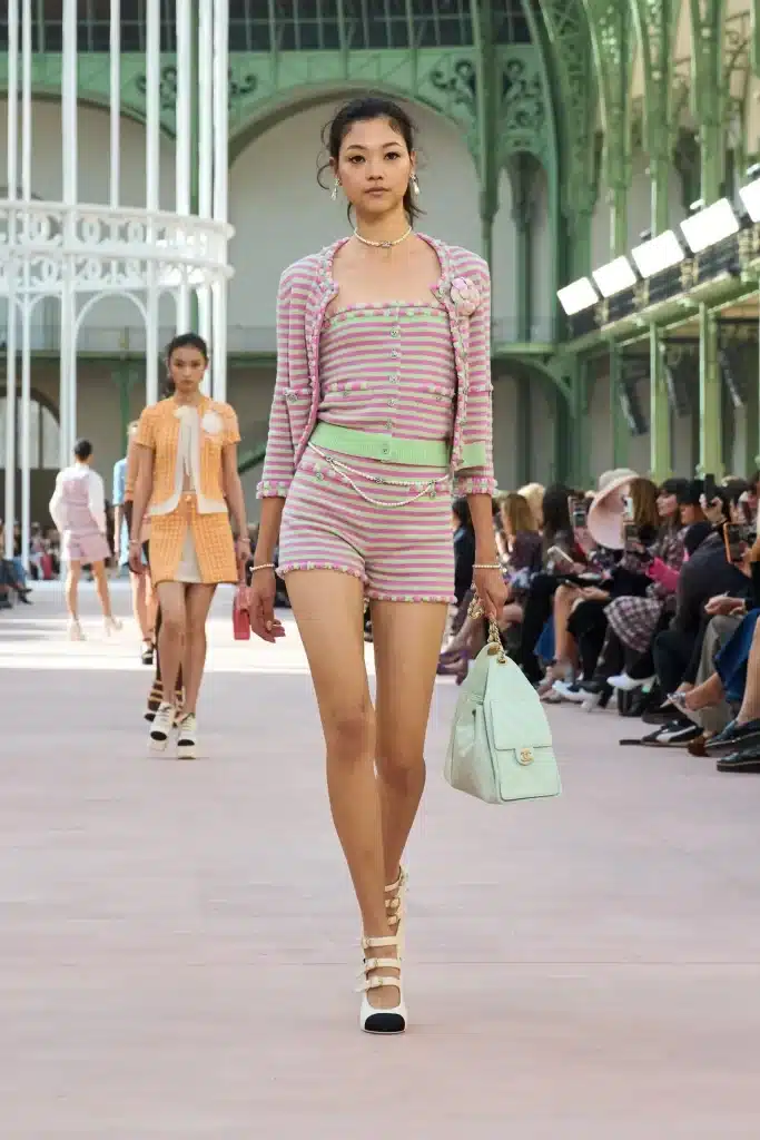 Model carrying a pastel mint green Chanel handbag on the Spring 2025 runway, showcasing one of the top bag trends 2025