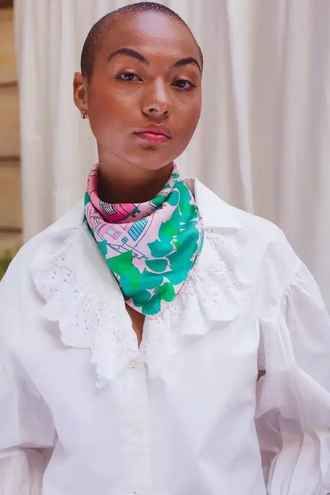 A silk scarf with an illustrated Montmartre print by Petitjean Paris, featuring soft pinks and greens.