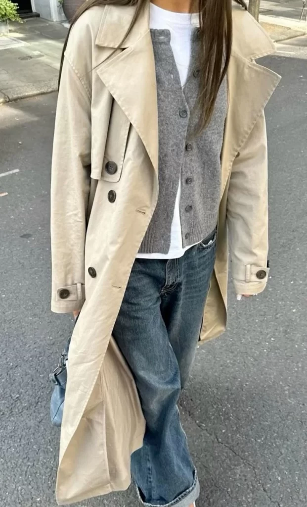 What to wear in Paris in the spring – a classic beige trench coat layered over a casual outfit.