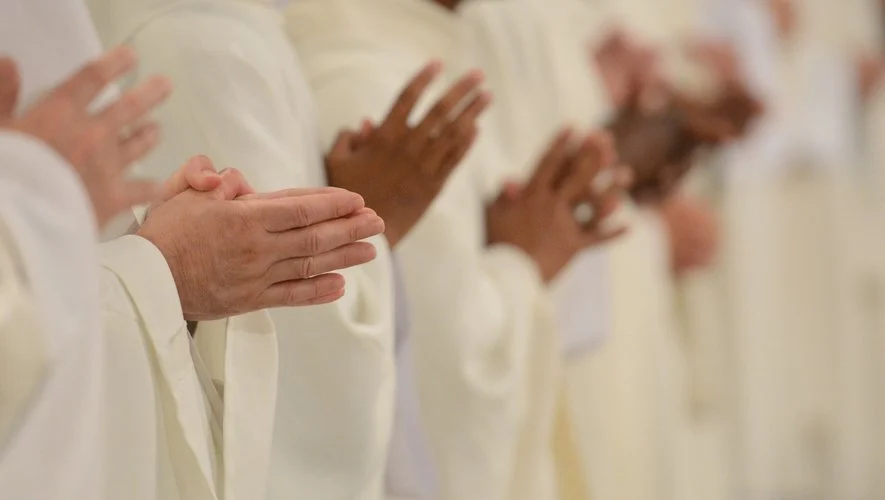 Close-up of hands in prayer during Easter Mass in France