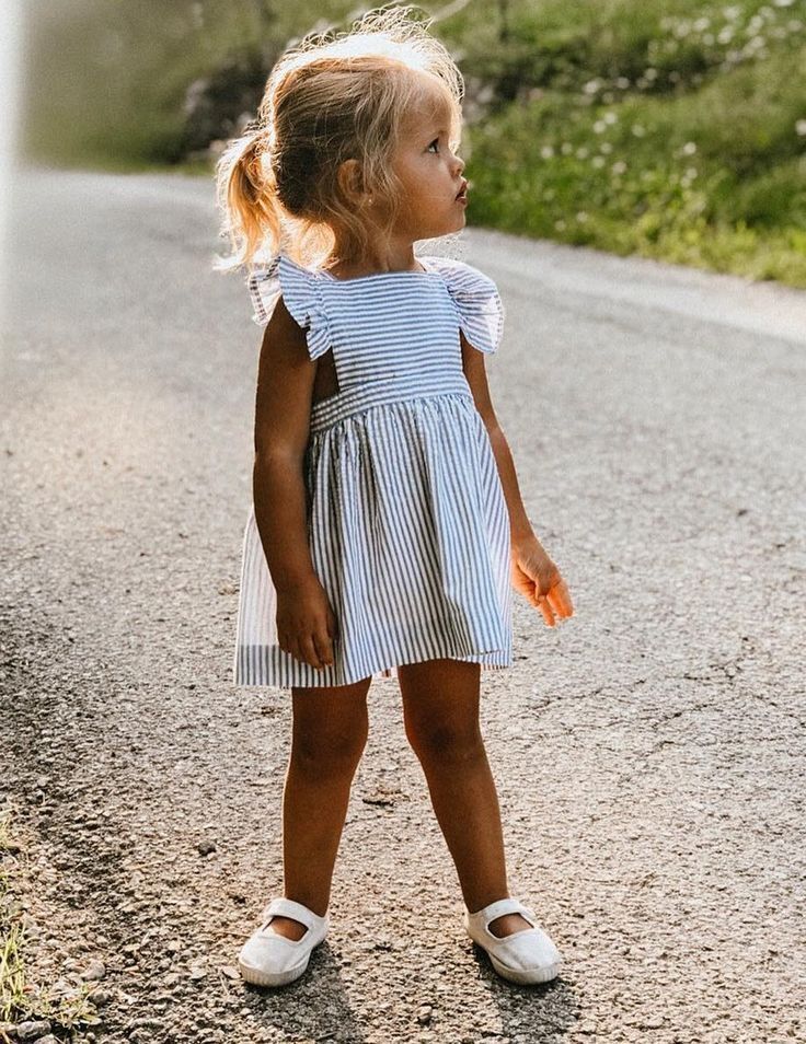 Young girl in a striped dress and white shoes ready for Easter in France