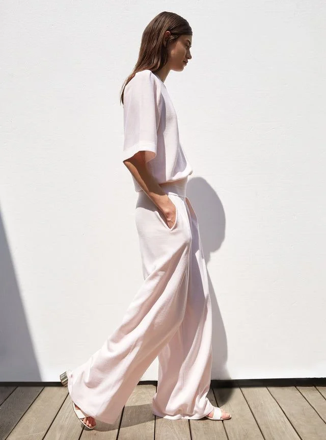 Woman wearing a flowing pale blush outfit, perfect for Easter in France