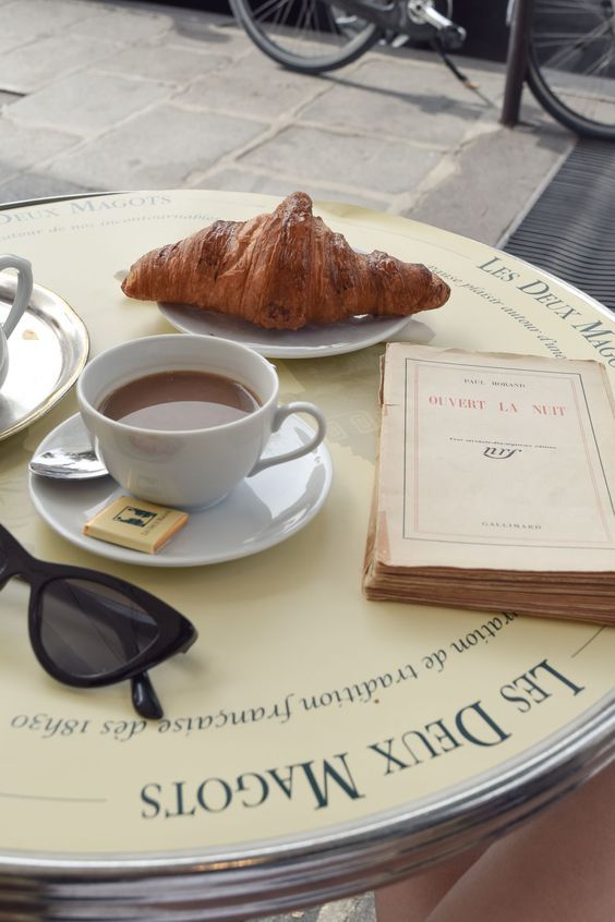 Croissant and coffee at a Paris café table showing how to eat like a French woman.