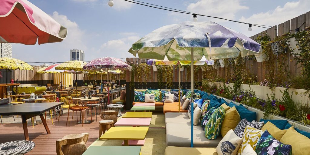 Colorful umbrellas and lounge seating on Mama Shelter Paris rooftop
