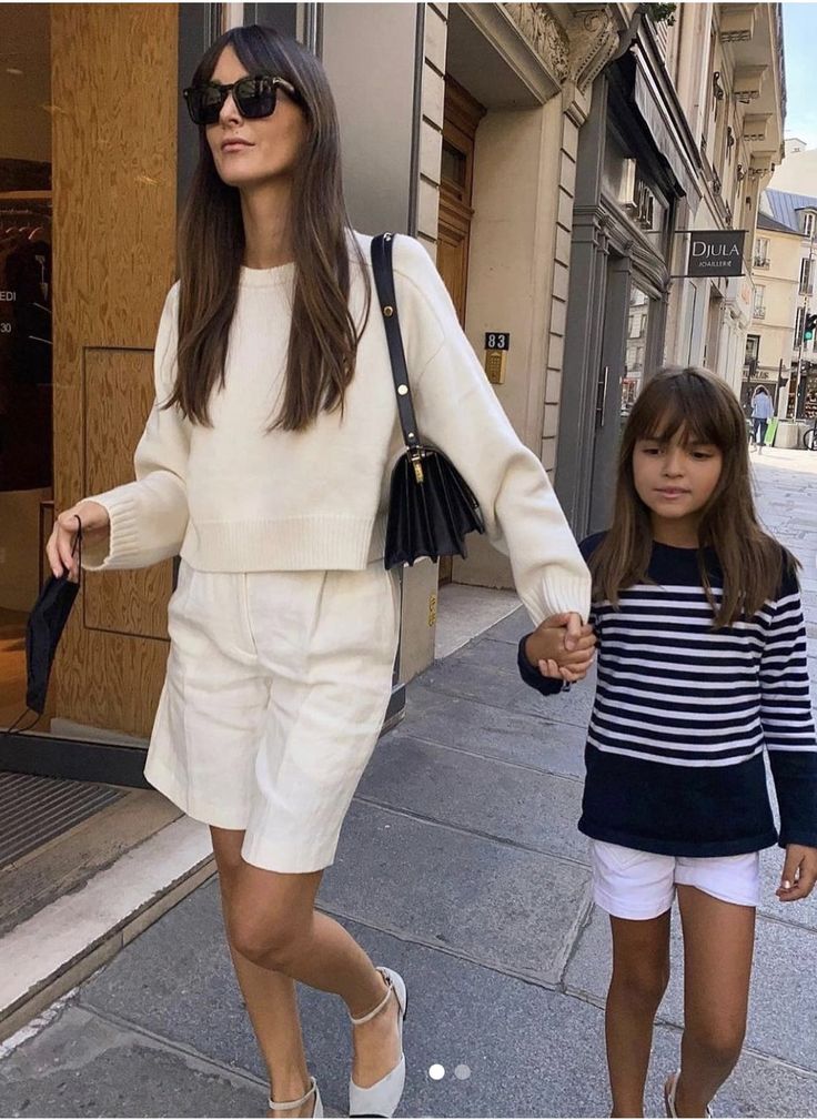 Parisian woman wearing tailored ivory shorts and sweater, stylish summer outfit inspiration
