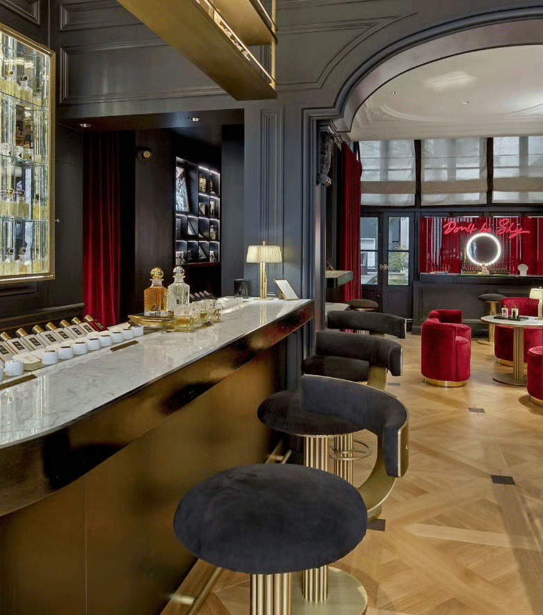 Opulent by Kilian perfume boutique with black and red velvet seating and gold accents. french perfume shops in paris