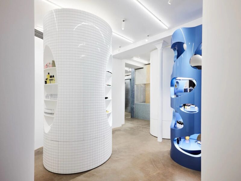 Contemporary mirrored perfume boutique interior with geometric wood shelves. french perfume shops in paris