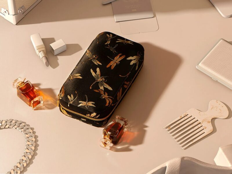 Miniature perfume bottles from Henry Jacques surrounded by luxury accessories