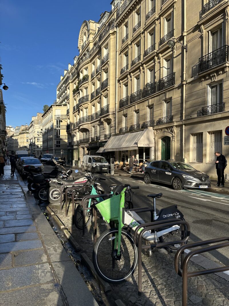 A Paris street with bikes parked and Haussmann buildings in the background