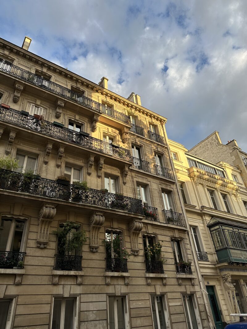 Parisian building lit by golden hour sunlight in October.