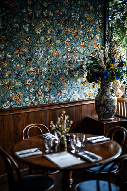 A cozy corner of Hotel Providence Paris with floral wallpaper and vintage decor.