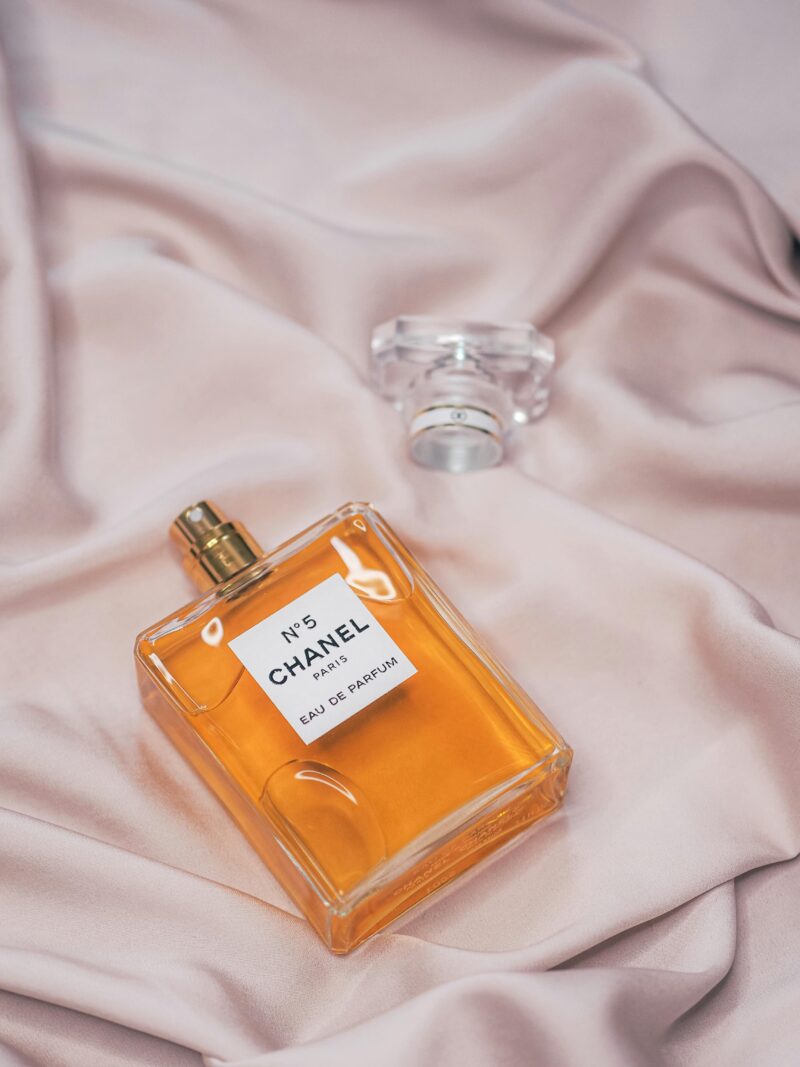 Chanel No. 5 perfume bottle resting on silky pink fabric, symbolizing the history of perfume.