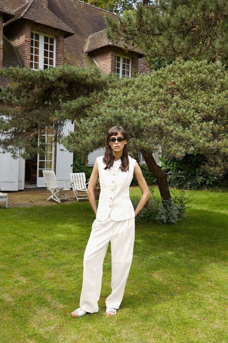 Woman wearing Roseanna’s Top Jessie and matching wide-leg pants in a garden setting