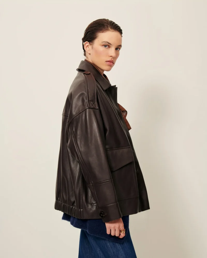 Model wearing a brown leather jacket by Sessùn, showcasing the minimalist Parisian style that defines classic French fashion.