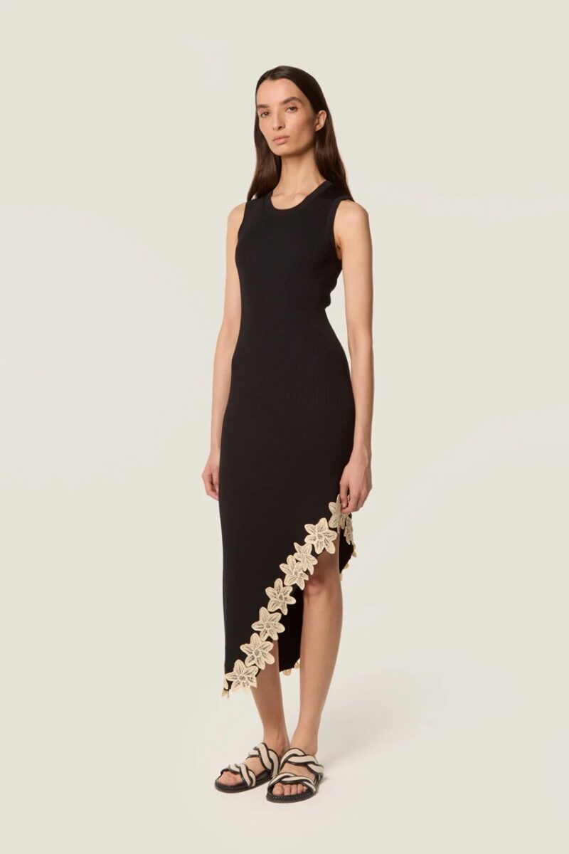 Model wearing a black Tressé midi dress with crochet flower hem