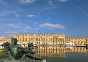 The Palace of Versailles with its reflecting pool and statue, a must-see day trip from Paris. Photo by Arsonela via Pexels.