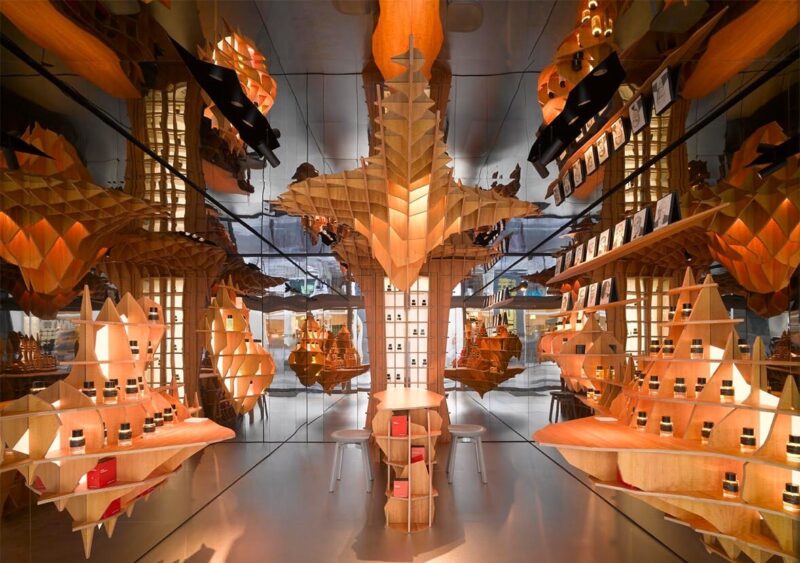 Interior of Frédéric Malle perfume boutique in Paris with sculptural wooden shelving, representing fragrance by notes exploration