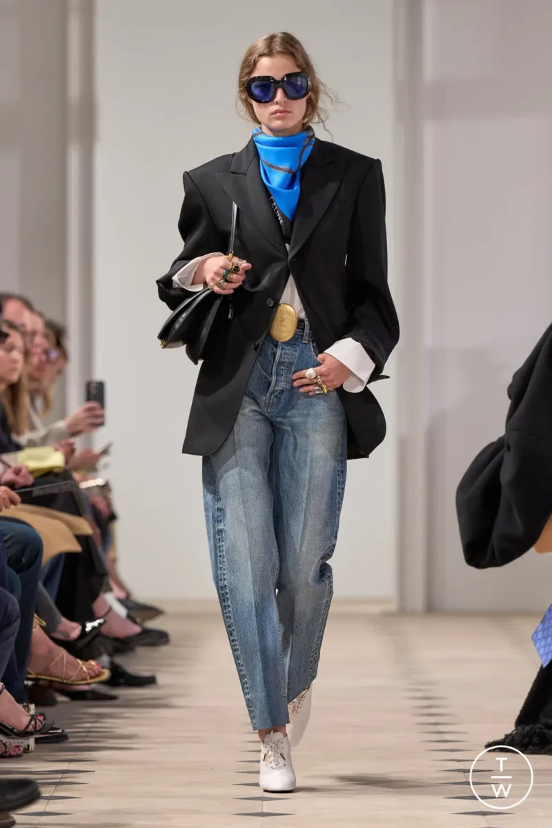 Celine AW25 model in Parisian style jeans with oversized blazer and bold accessories.