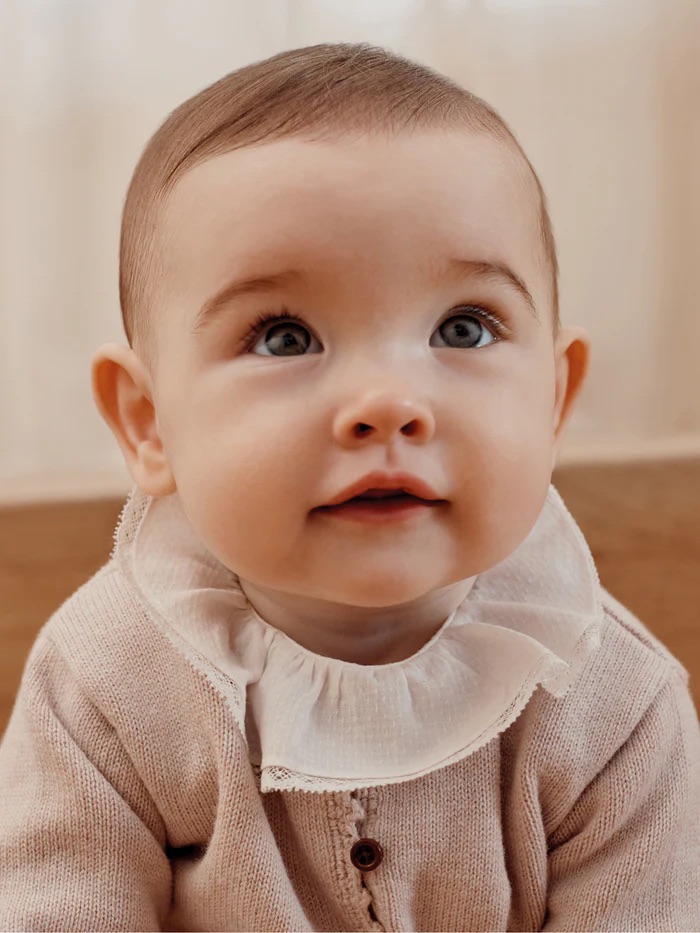 Baby wearing a knitted sweater from Bonpoint, one of the best French baby clothing brands.