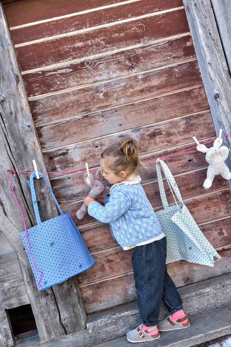 A baby girl in an outfit from Bonton, a French baby clothing brand.