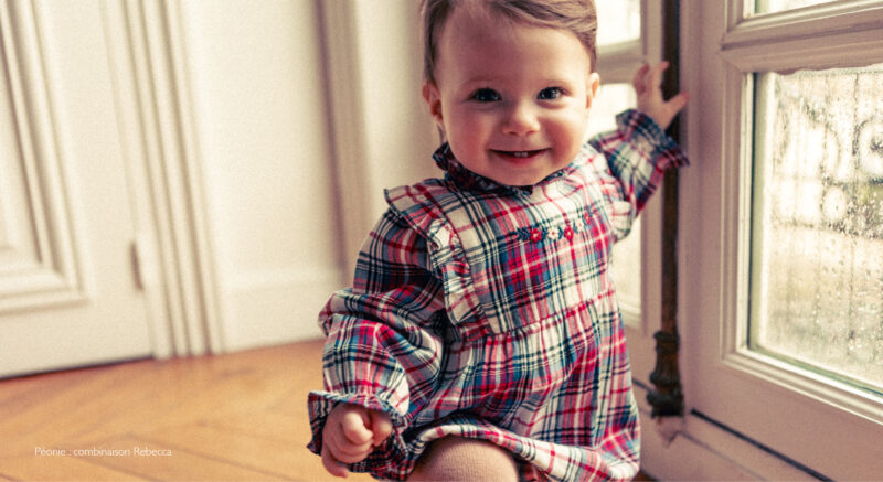 Baby in an embroidered outfit from Louis Louise, a French baby clothing brand.