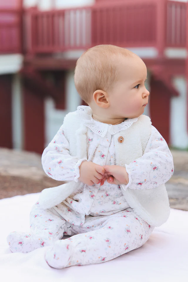 Baby in white floral pajamas with vest from Tartine et Chocolat
