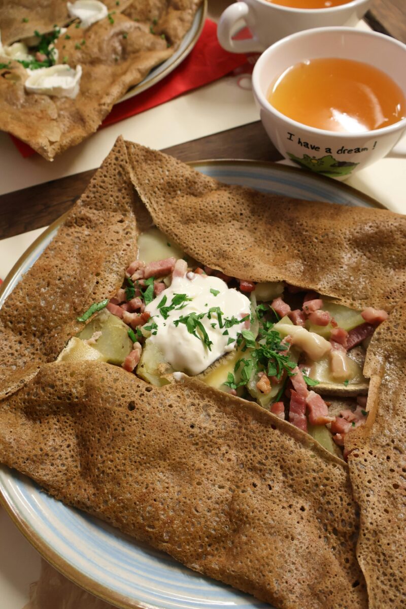 Buckwheat galette filled with ham, egg, and cheese, served with cider