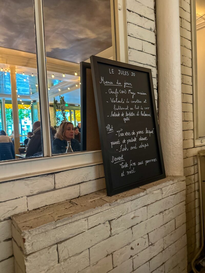 Parisian café interior with chalkboard menu and diners in November