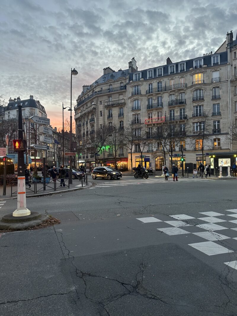 Vavin intersection in Montparnasse with Haussmann buildings and brasseries at dusk in November