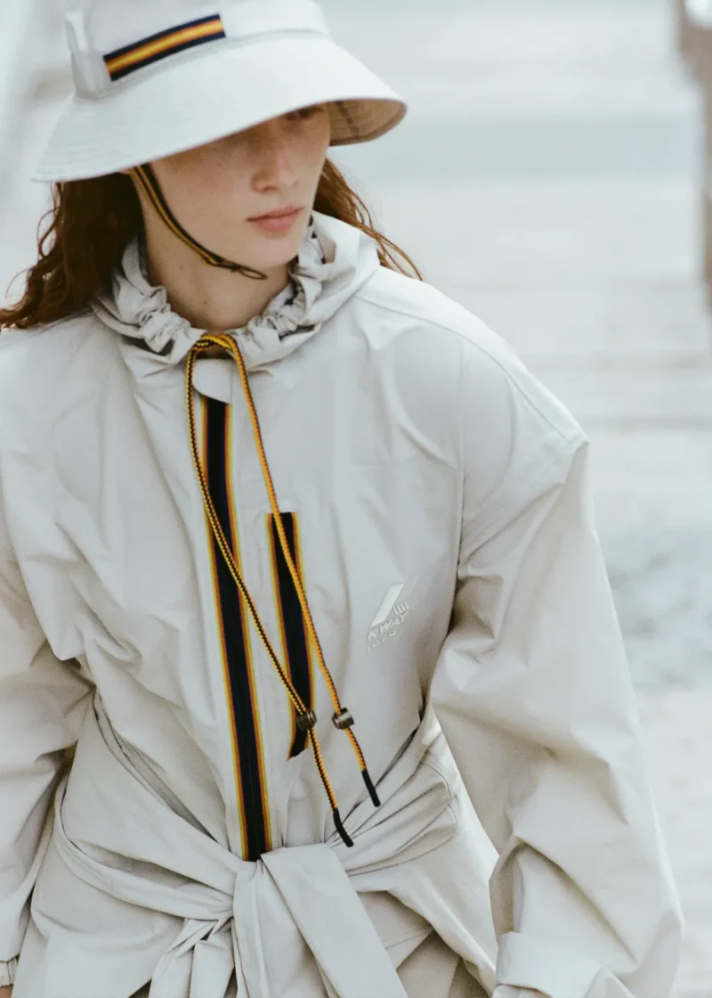 Woman in Paris wearing a trench coat and wide-brim hat, a chic rain outfit idea for what to wear in Paris in the rain.