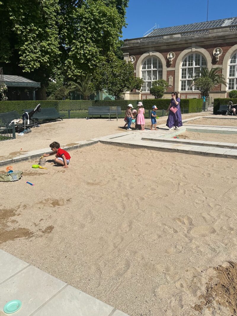 Children playing in a sandbox at a Paris park playground