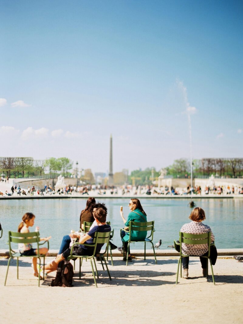 People sitting on benches by the Seine in Paris