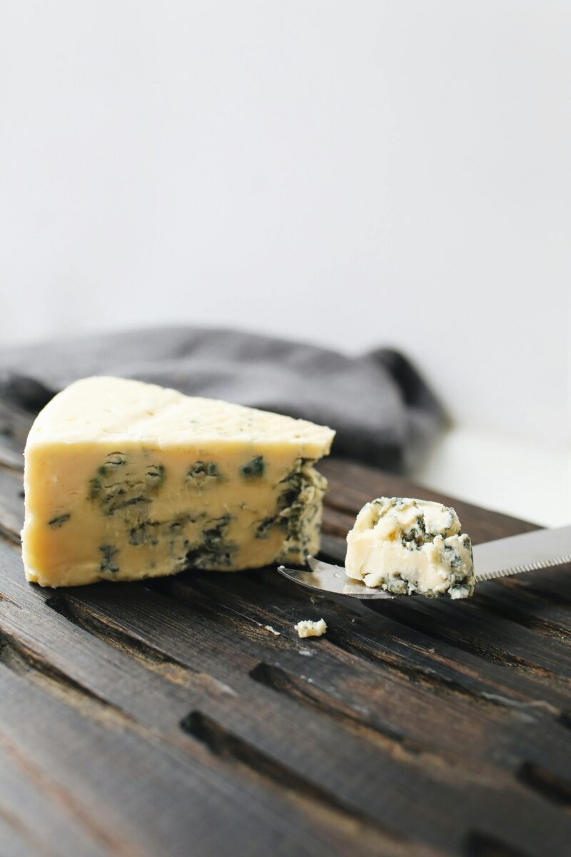 A wedge of Roquefort blue cheese on a rustic wooden board