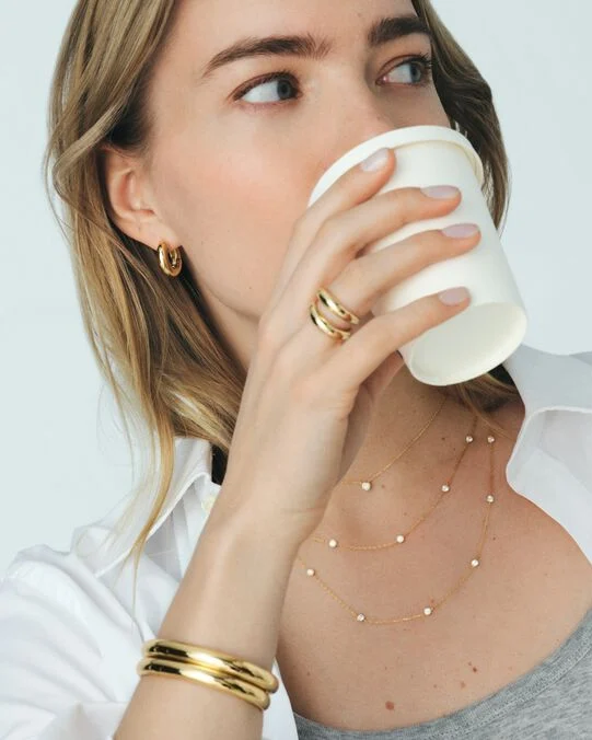 Woman wearing Agatha Paris gold hoop earrings