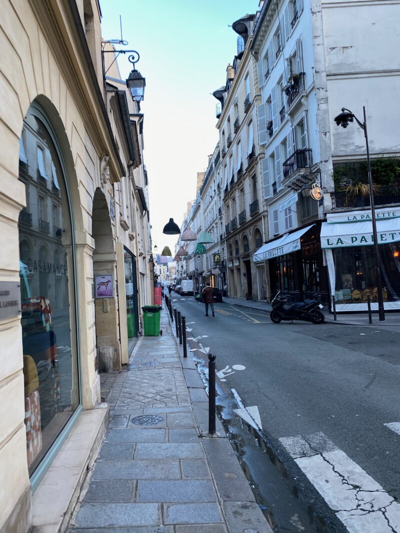 View of Rue de Seine with early morning light and classic Parisian façades. A sunlit café terrace captures the relaxed, elegant rhythm of Saint-Germain mornings — the perfect mood for discovering Paris’s most atmospheric neighborhood.