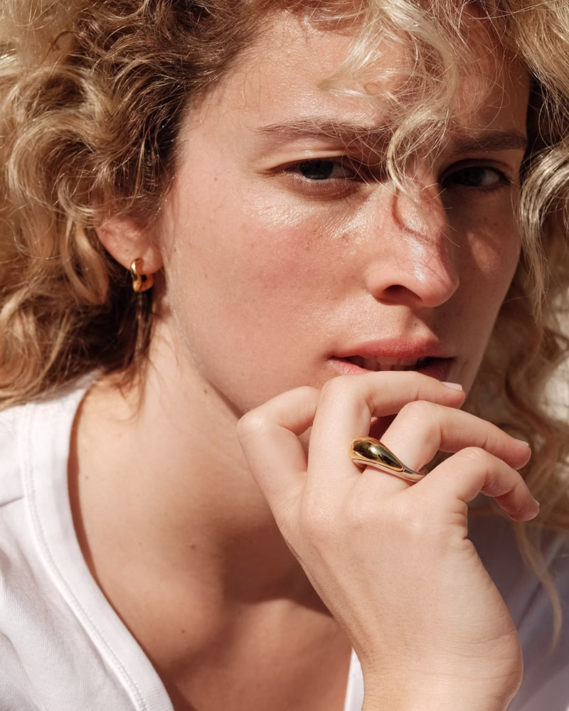 Woman wearing sculptural gold ring by Charlotte Chesnais, one of the leading Parisian jewelry designers.