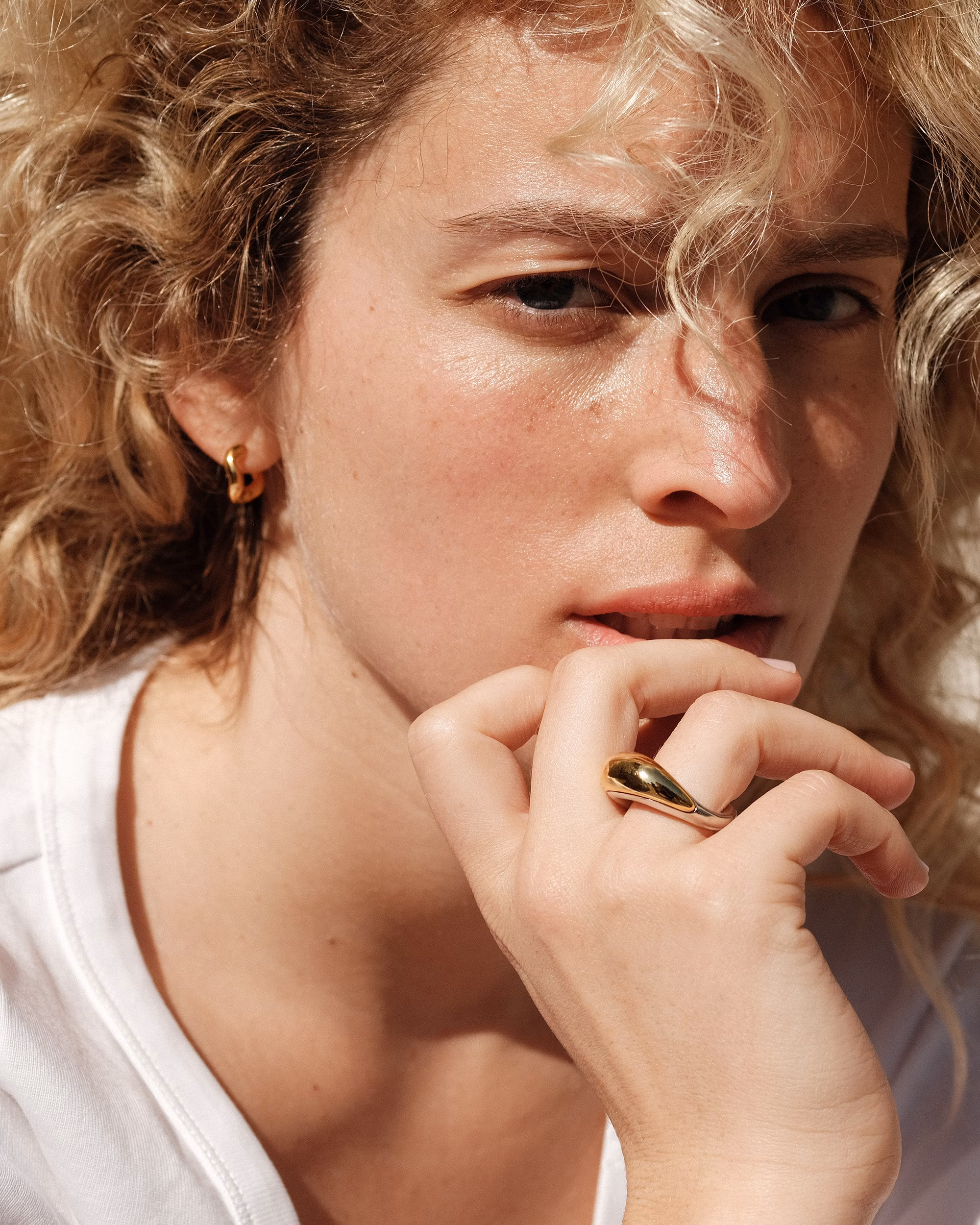 Woman wearing sculptural gold ring by Charlotte Chesnais, one of the leading Parisian jewelry designers. shopping in saint-germain paris